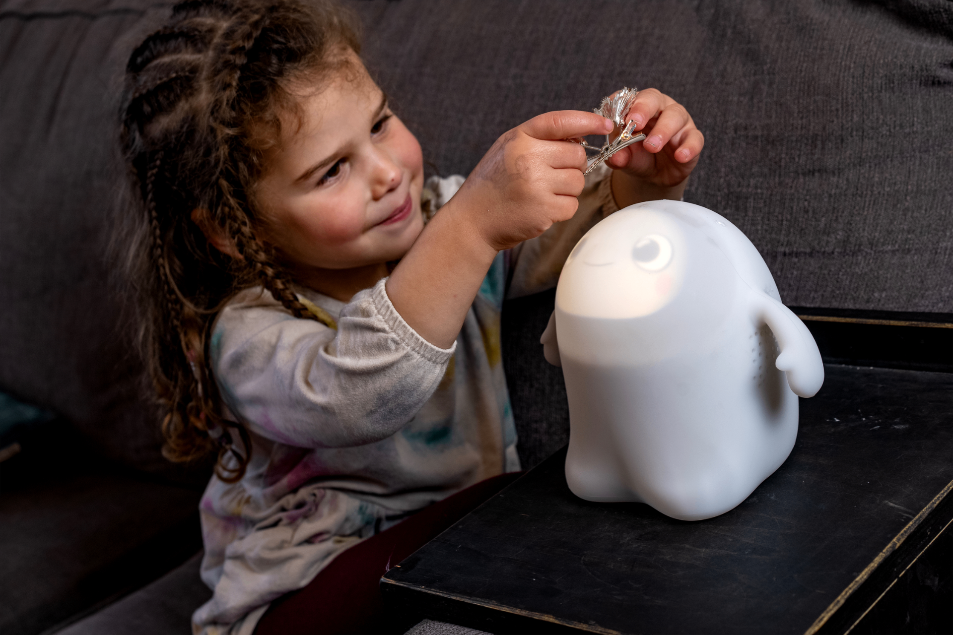 Young girl playing with glowing Snorble on the floor